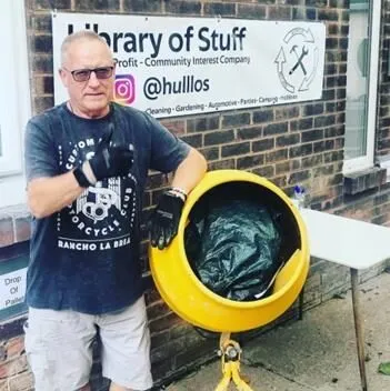 A member holding the library's yellow cement mixer outside the Library of Stuff