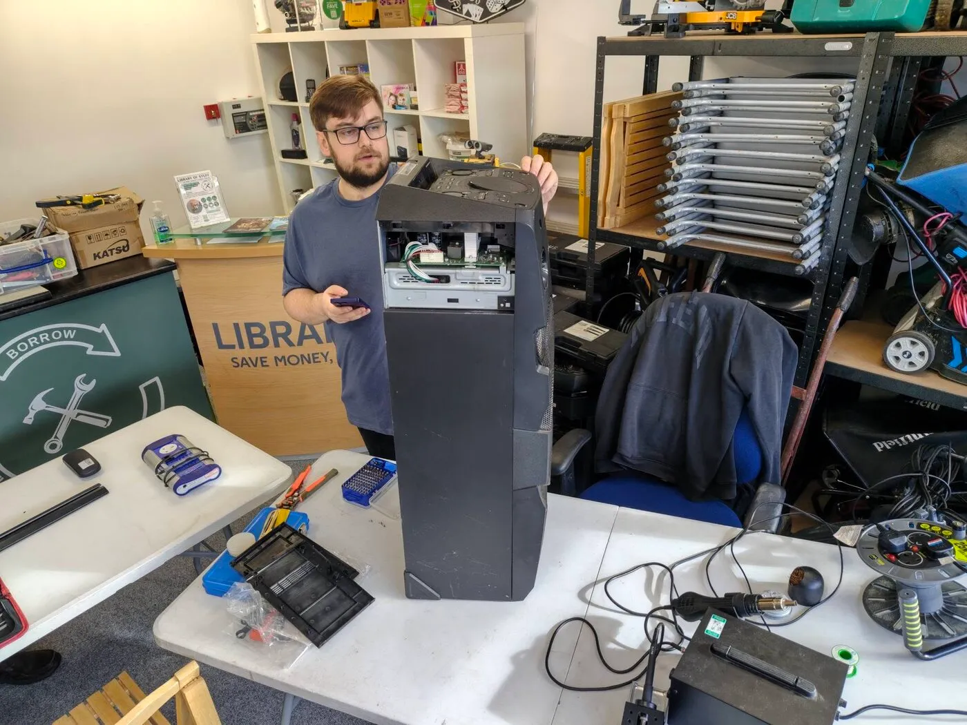 A young adult on the Exploring Employment project repairing a party speaker on the library workbench